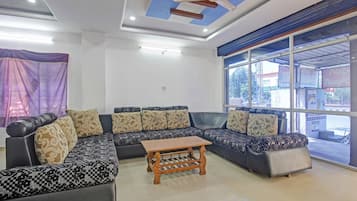 A modern living room with a sectional sofa, a wooden coffee table, and a ceiling fan.