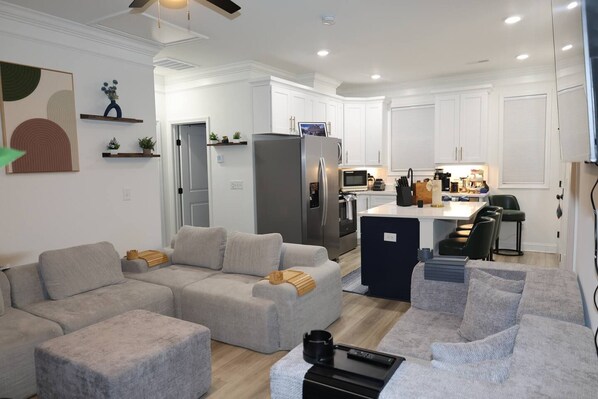 A modern living room with a grey sectional sofa, a small coffee table, and a TV.
