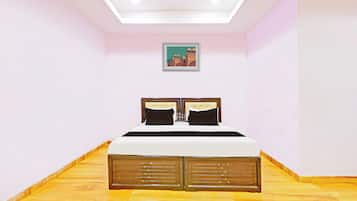 Ein Schlafzimmer mit einem Bett, einem Deckenventilator, einem gerahmten Bild an der Wand und Holzböden.
