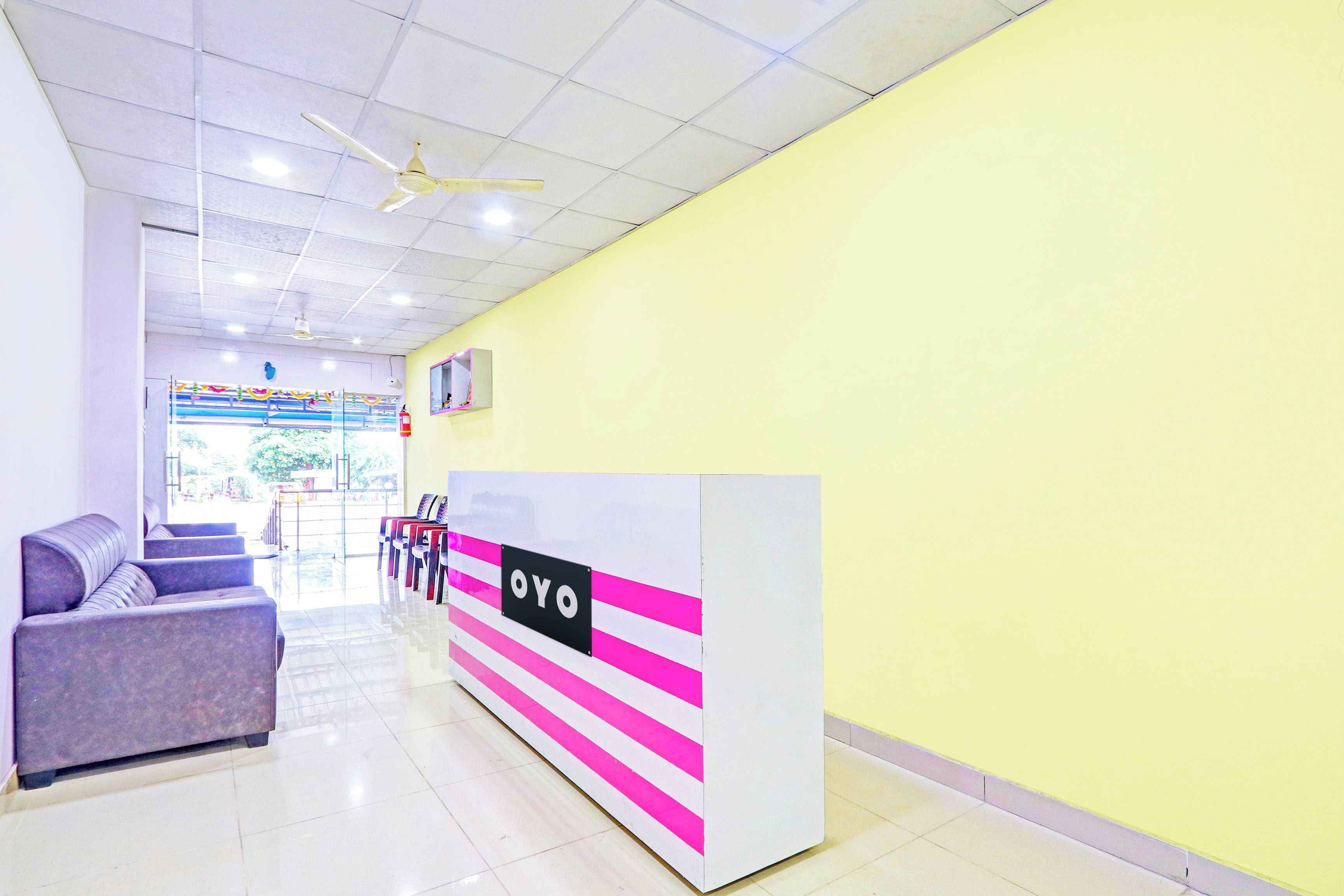 A reception area with a reception desk, seating, and a ceiling fan.