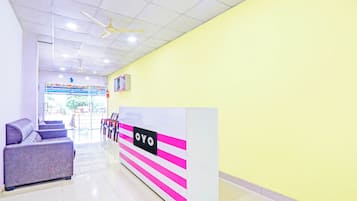 A reception area with a reception desk, seating, and a ceiling fan.
