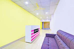 Una zona de recepción con un sofá y un mostrador.