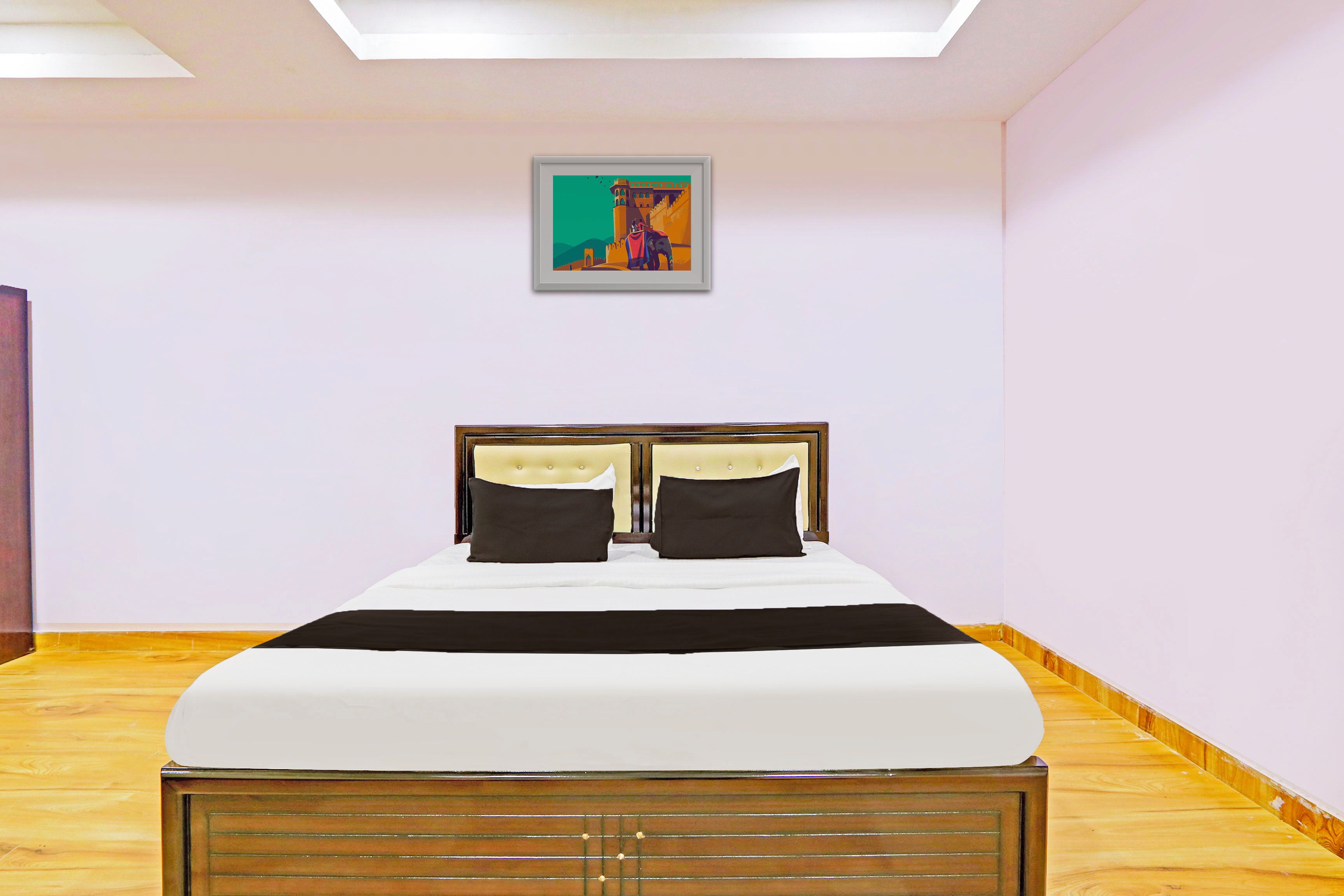 Een slaapkamer met een bed, een hoofdeinde, een schilderij aan de muur en houten vloeren.