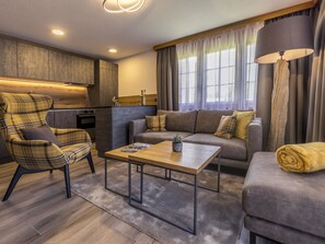Uma sala de estar moderna com sofá, poltrona, mesa de centro e luminária.