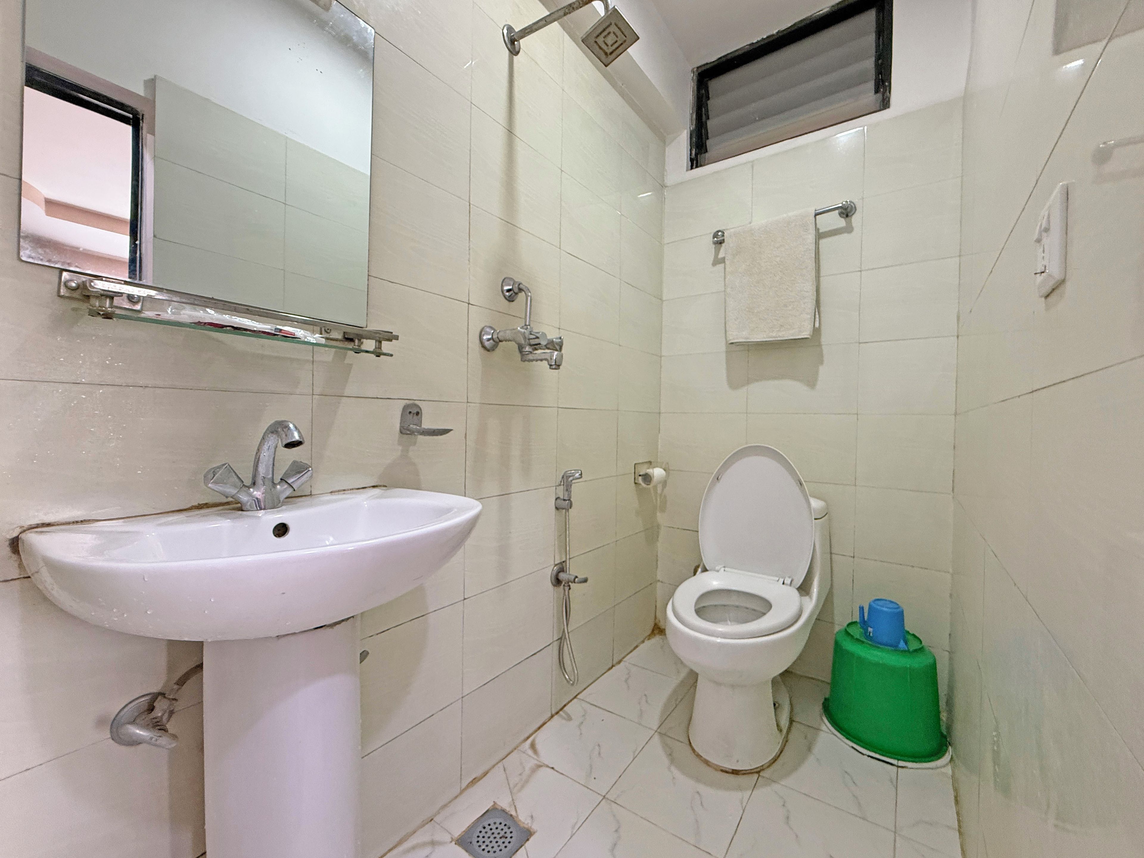 Un baño con lavamanos, inodoro, ducha y espejo.