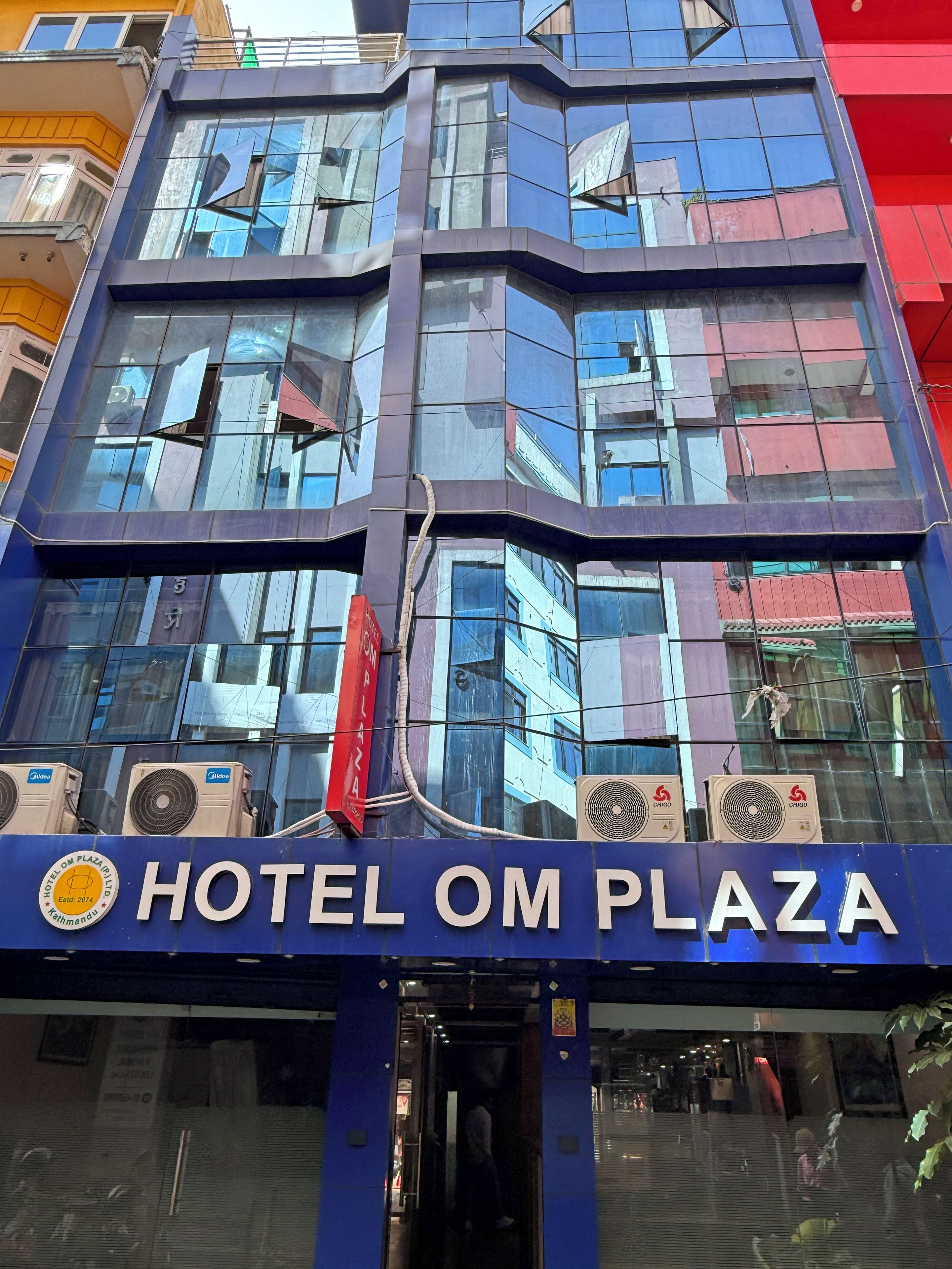 Un edificio moderno con el letrero del Hotel Om Plaza.