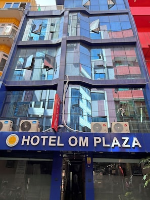 Un edificio moderno con el letrero del Hotel Om Plaza.