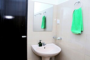 A bathroom with a white sink, a green towel hanging on a ring, and a mirror above the sink. - Breathtaking Mountain & Rainforest Views / Cozy 2- Bed HilltopBungalow (SP)