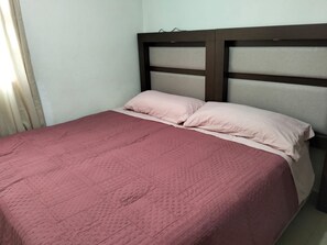 A bed with a headboard, a pink bedspread, and two pillows. - Penthouse ideal for work groups or family vacations, in a great location (Cuautitlán Izcalli)