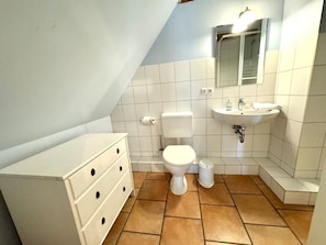 Ein kleines Badezimmer mit Toilette, Waschbecken und einem Schrank.