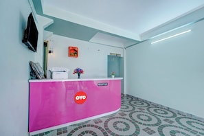 A reception desk with a 'Reception' sign, a 'OYO' logo, and a potted plant. - Hotel O City View (Patna)