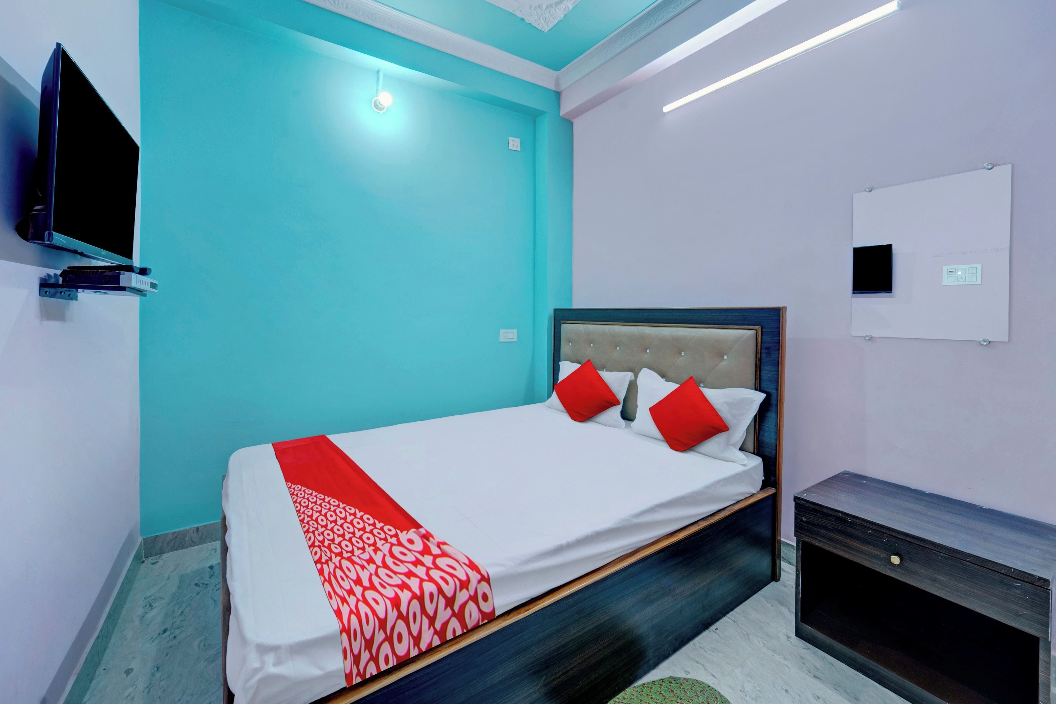 Una habitación de hotel con cama, televisor y escritorio.
