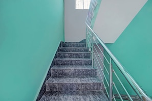 A staircase with a metal handrail and marble steps. - Hotel O City View (Patna)