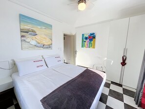 A hotel room with a bed, a painting, a door, and a wall with a colorful abstract painting. - Moderne Zeiten by Interhome (Zinnowitz)