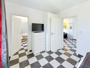 A hallway with a checkered floor, white walls, and doors leading to other rooms. - Moderne Zeiten by Interhome (Zinnowitz)