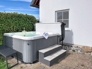 A hot tub with steps leading up to it, a bottle of wine, and glasses on the edge. - Moderne Zeiten by Interhome (Zinnowitz)