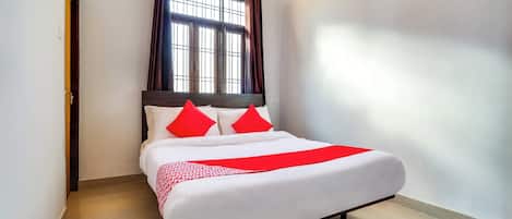 Habitación de hotel con cama, cortinas, ventana y puerta.