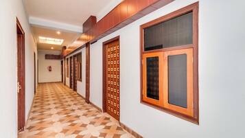 A hallway with patterned flooring, wooden doors, and a fire extinguisher.