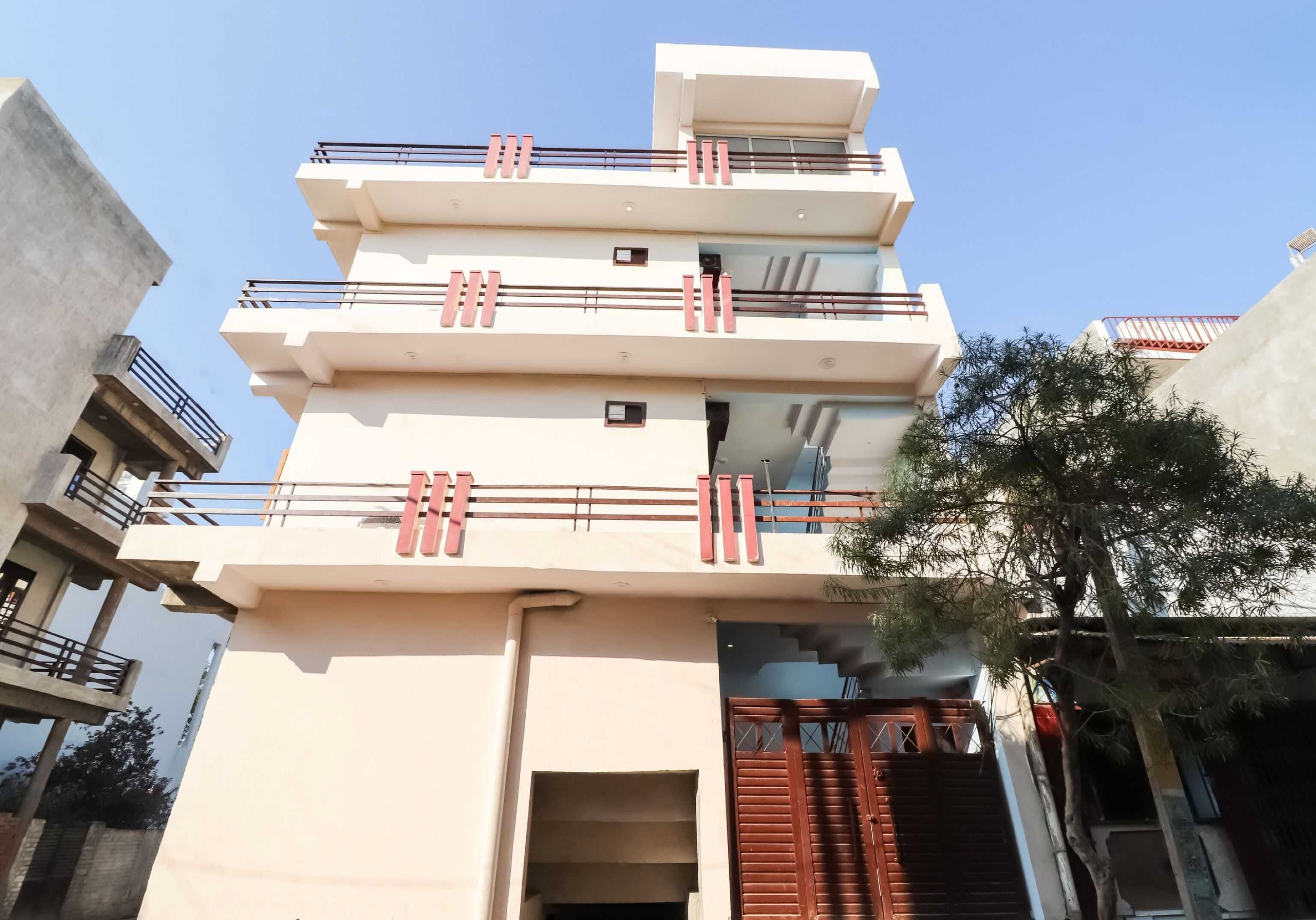 A multi-story building with balconies and a gated entrance.