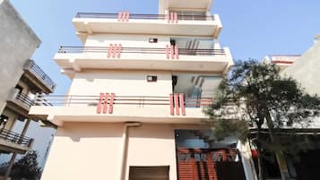 A multi-story building with balconies and a gated entrance.