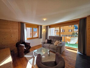 A modern living room with a glass coffee table, a sofa, and a pet bed. - Dominic A1 Appartement/Fewo Appartement/Fewo by Interhome (Saas-Fee)
