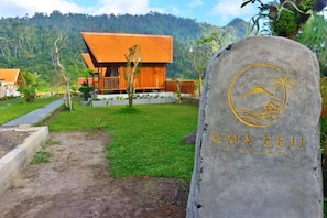 A stone sign with 'UMA BEIJ VILLA' and a palm tree symbol, indicating a villa setting.