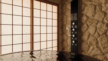 Un baño con pared de piedra, una bañera y una ventana con diseño de cuadrícula.