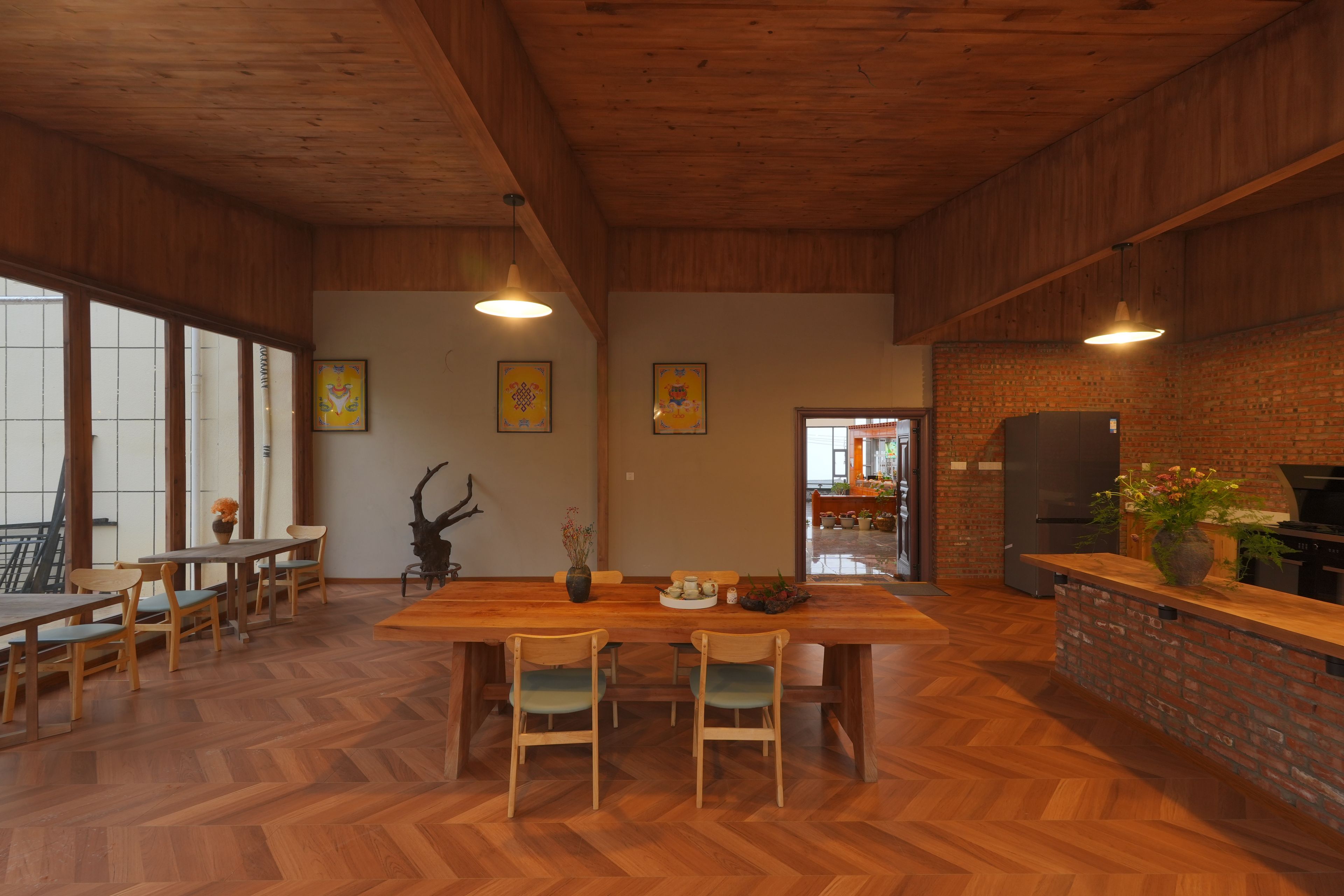Una cocina amplia con piso de diseño espiga, muebles de madera y pared de ladrillo.
