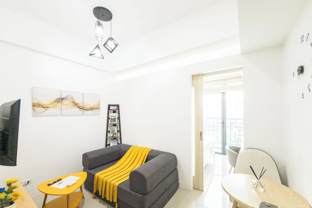 Una sala de estar moderna con un sofá, una mesita y una estantería.