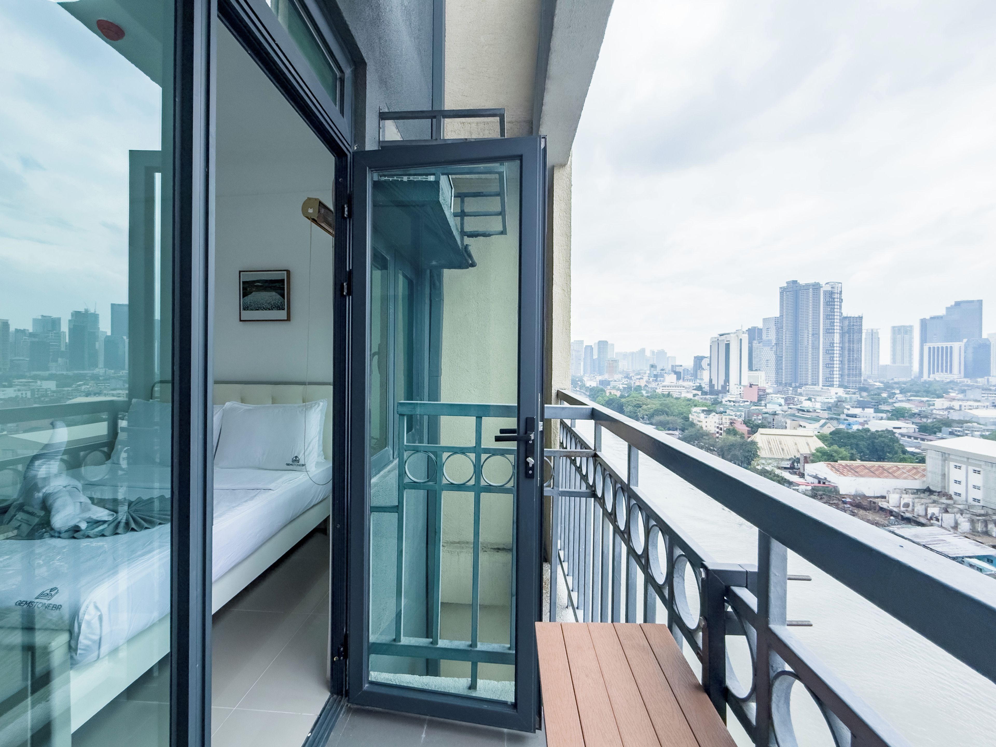 A balcony with a city view, a sofa, and a table.