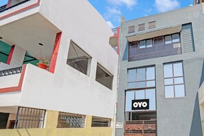 Un edificio de varios pisos con fachada plana, ventanas amplias y un letrero visible que dice 'OYO'.