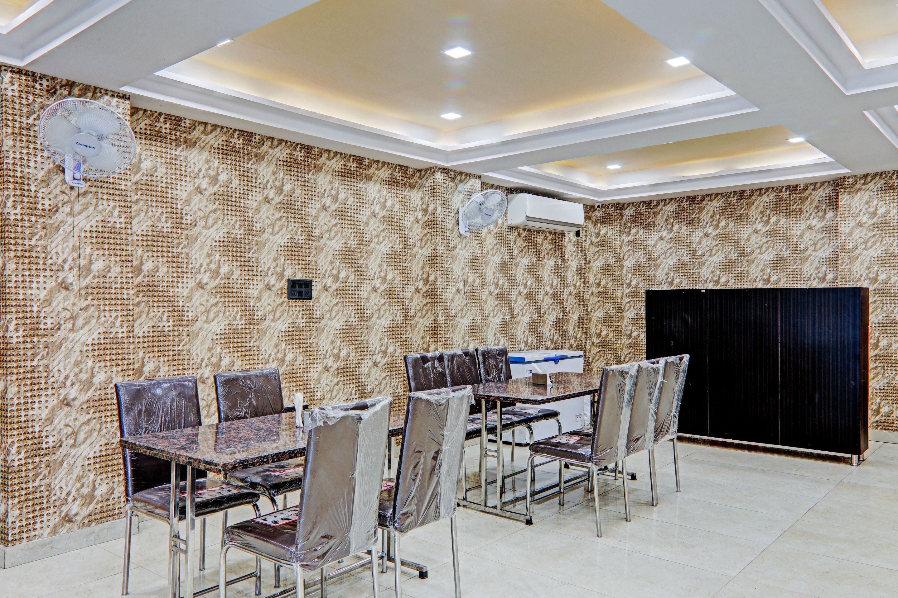 Un salón de conferencias con una pared estampada, techo con iluminación empotrada y un equipo de aire acondicionado grande.