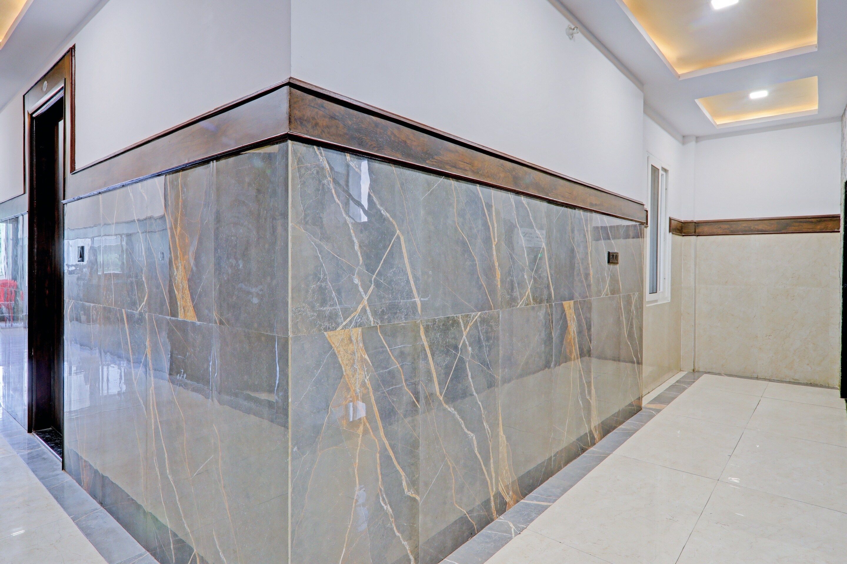 A lobby with a marble reception desk, a door, and a tiled floor.