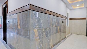 A lobby with a marble reception desk, a door, and a tiled floor.