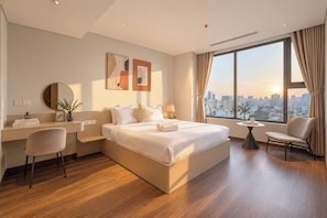Habitación de hotel moderna con una cama grande, un escritorio, una silla y vistas a la ciudad.