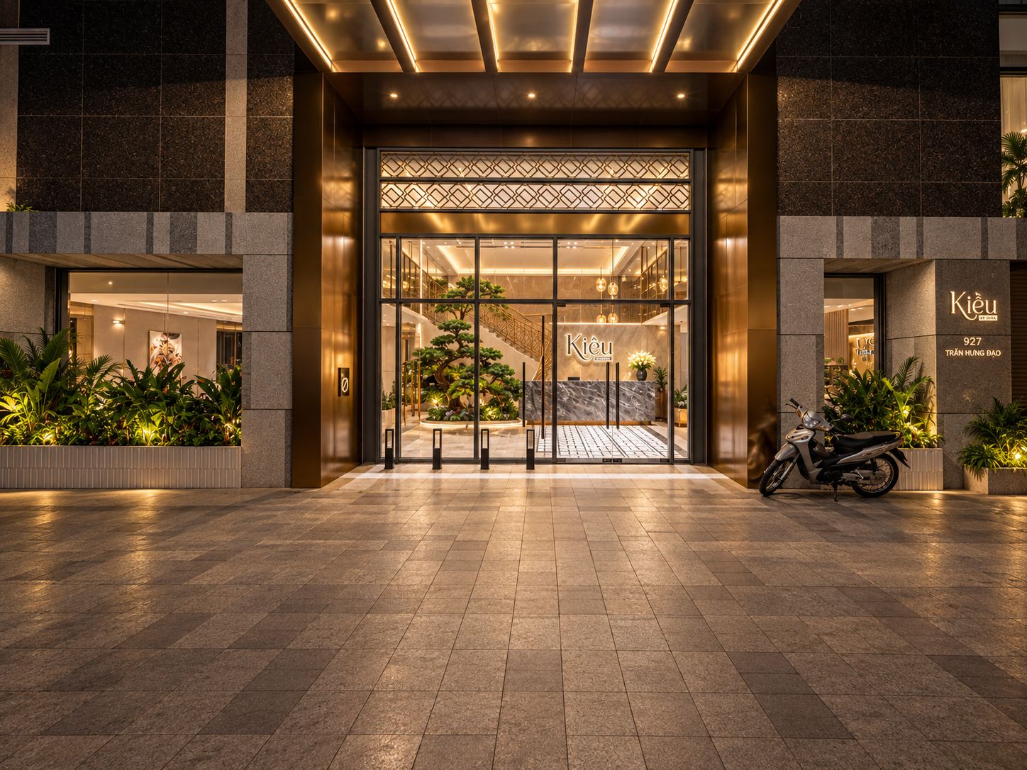 Entrada d'hotel amb disseny modern, una recepció i una escala que condueix als pisos superiors.