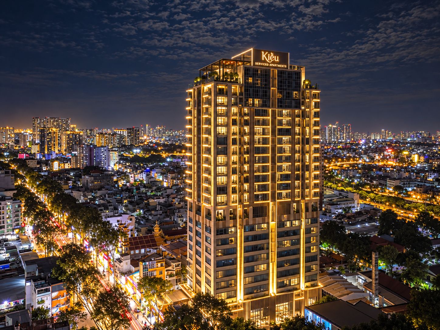 A high-rise building with a sign indicating it is a serviced apartment complex.
