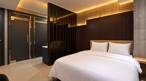 A modern hotel room with a large bed, a wardrobe with sliding doors, and a wooden panel wall. - Herium Hotel Gumi (Gumi)