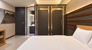 A hotel room with a bed, a wardrobe, a mirror, and a wooden shelf. - Herium Hotel Gumi (Gumi)