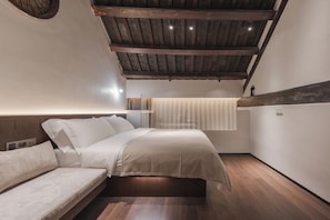 A bedroom with a wooden ceiling, a bed with white bedding, a wooden floor, and a window with curtains. - 17435924 (Jinan)