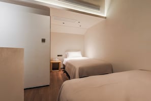 A hotel room with a bed, bedside table, and a small wooden stool. - 17435924 (Jinan)