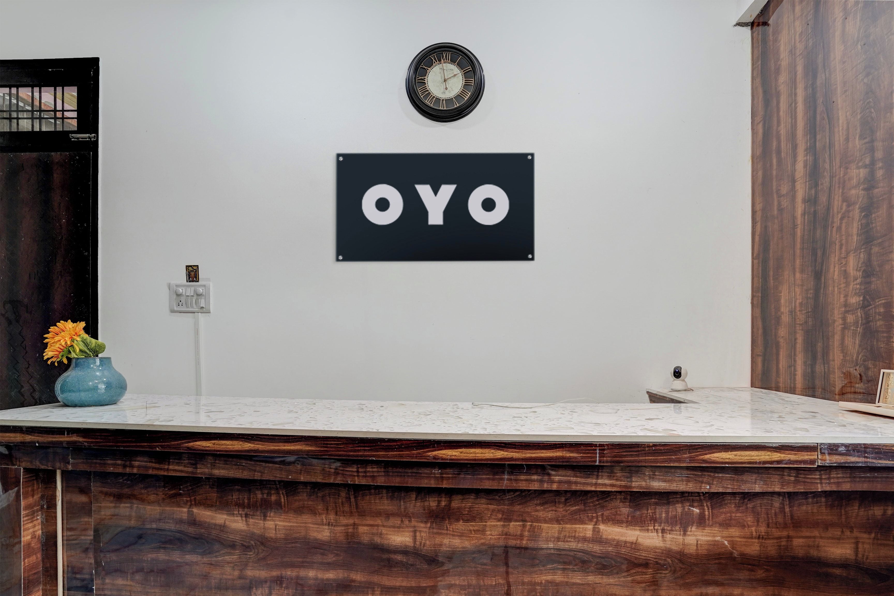 Una mesa de recepción con un reloj encima y un cartel que dice 'OYO'.