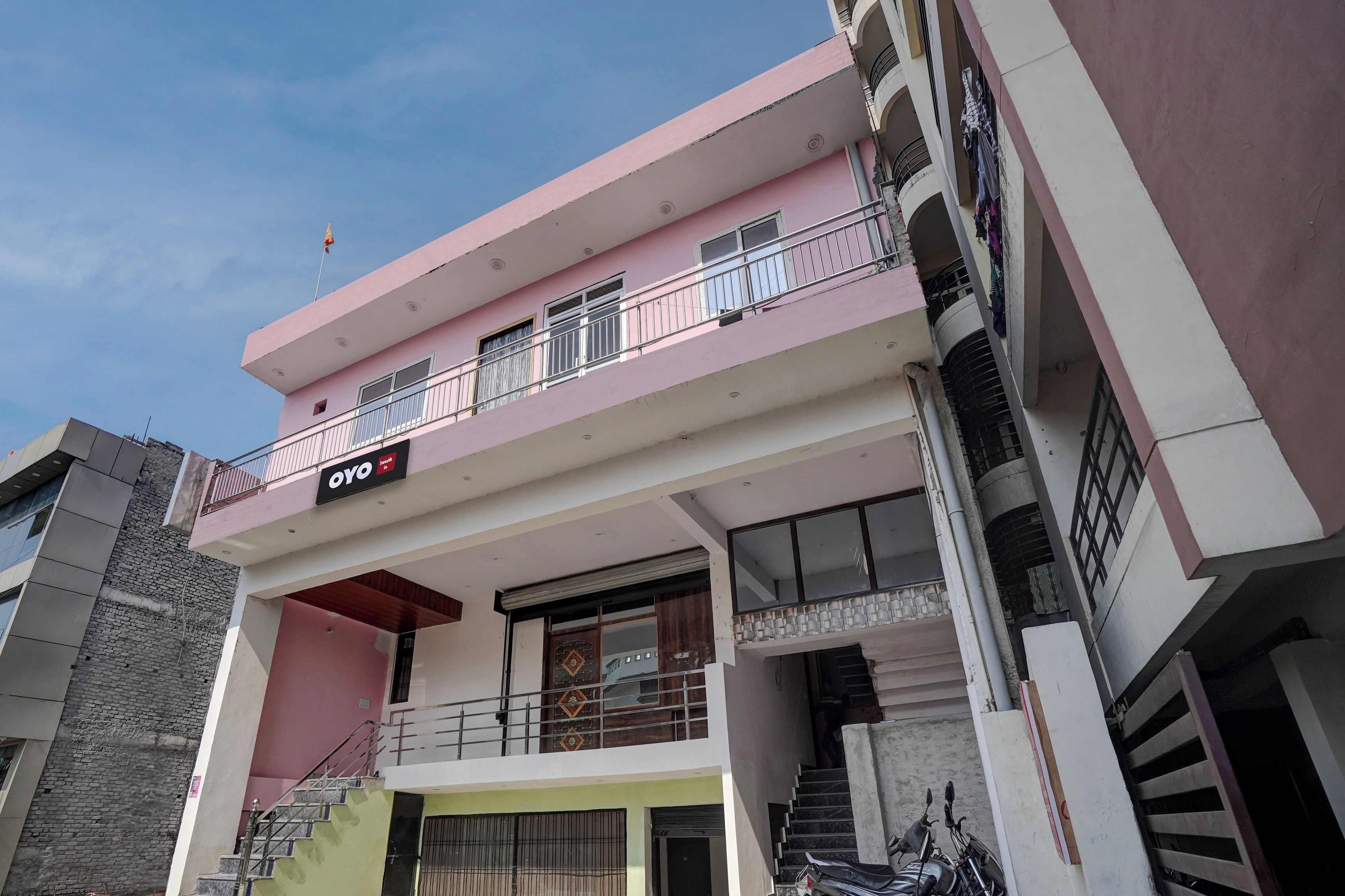 Un edificio de varios pisos con balcones, una escalera y un letrero que dice 'OYO'.