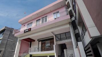 Un edificio de varios pisos con balcones, una escalera y un letrero que dice 'OYO'.