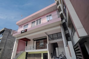 Un edificio de varios pisos con balcones, una escalera y un letrero que dice 'OYO'.
