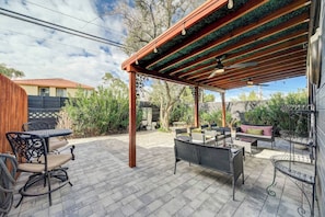 Eine Außenpatio mit einer Pergola, Sitzgelegenheiten und Blick auf die Umgebung.