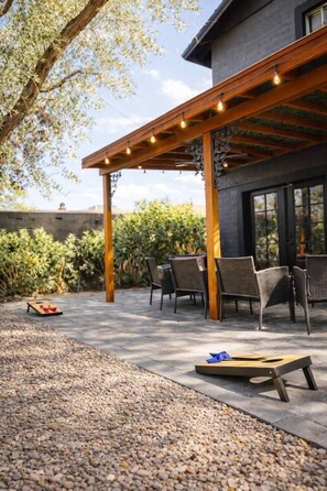 Eine Außenpatio mit Pergola, Sitzbereich und einem Kiesweg.