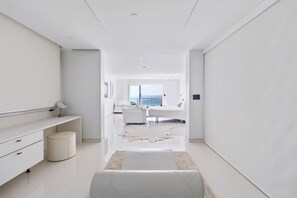 A modern, minimalist hallway leading to a living area with a view of the sea. - Penthouse w/ Ocean View, Oceania 331 by Bocobay (Noord)