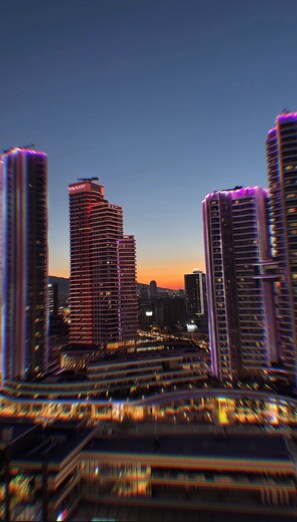 A cityscape at dusk with modern high-rise buildings. - İzmir’in kalbinde ışık şölenine hazır mısınız? (İzmir)