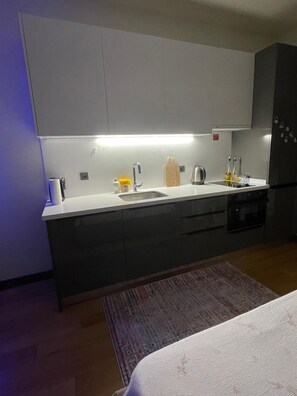 A modern kitchen with a built-in oven, a sink, and a countertop. - İzmir’in kalbinde ışık şölenine hazır mısınız? (İzmir)